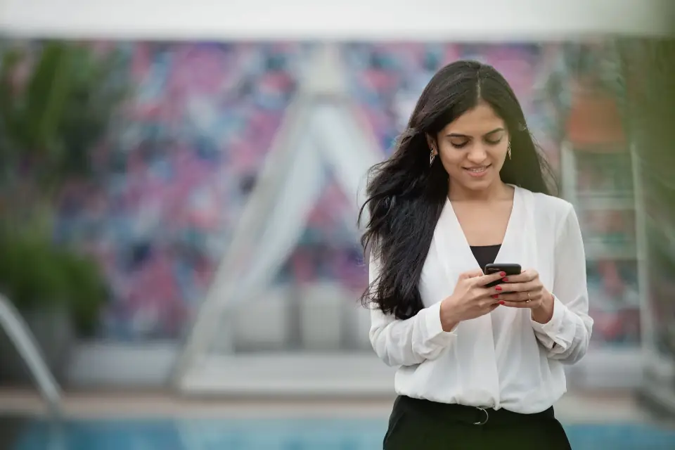 A smiling customer looking at a smartphone