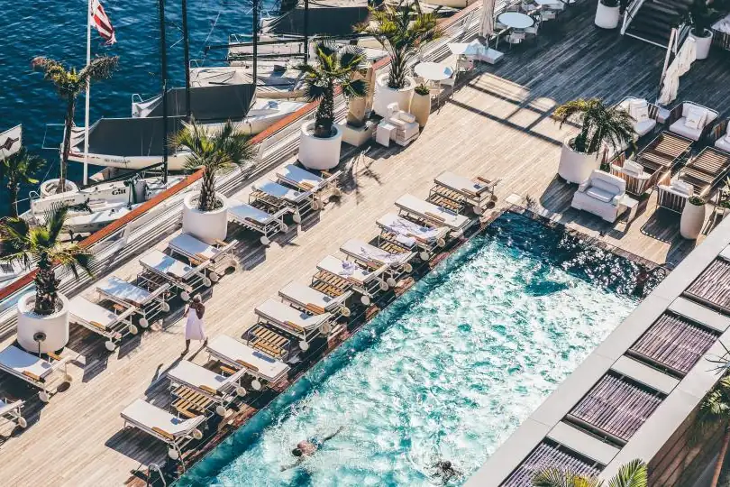 Aerial view of a hotel pool lined with sun loungers