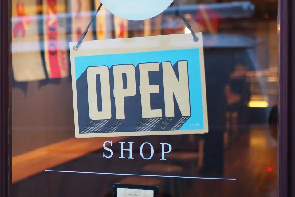 An "Open" sign hanging in a shop's glass door