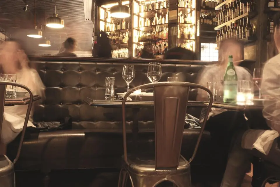 Guests at their tables in a busy restaurant dining room in the evening