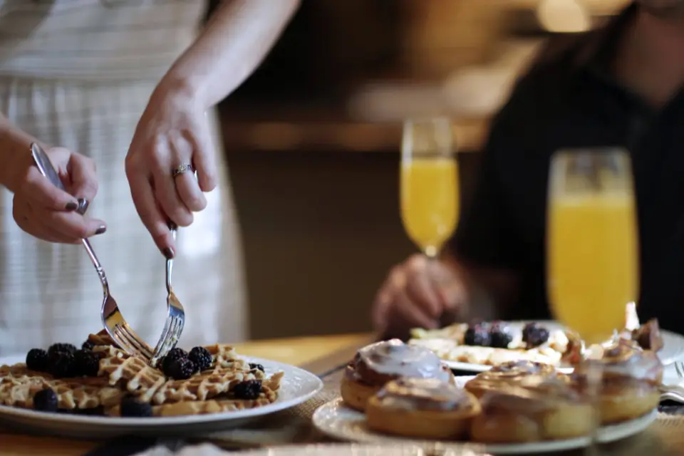 Guests sharing brunch dishes and drinks at a restaurant table