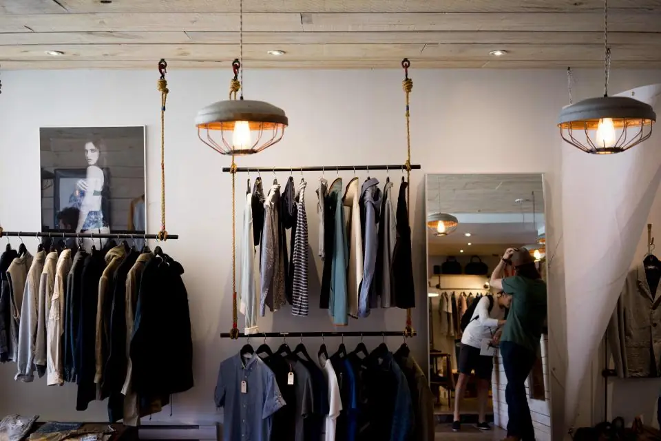 Clothing rails and a mirror inside a bright independent boutique