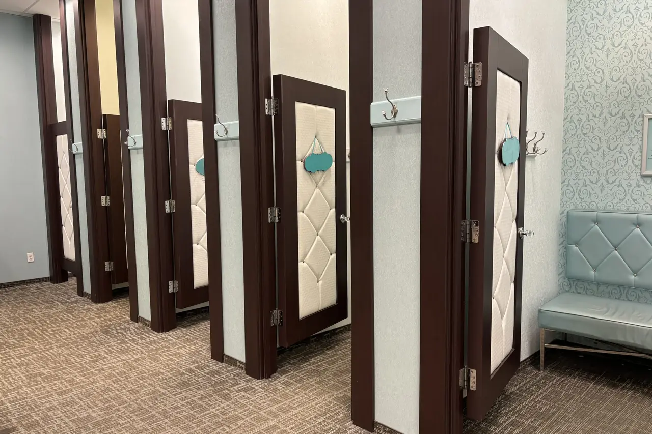 A row of fitting room doors in a clothing store